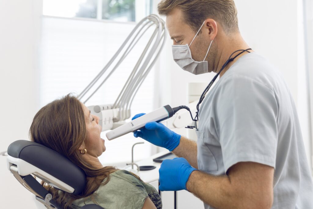 Zahnarzt Dr. Schulte von der Zahnmedizin an der Dhünn führt bei einer Patientin eine digitale Abformung mit dem modernen Intraoralscanner iTero Lumina durch.